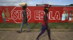 MONROVIA, LIBERIA:  People pass an Ebola awareness mural on October 2, 2014 in Monrovia, Liberia. More than 3,200 people have died in West Africa due to the epidemic.