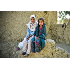 UNICEF/UNI427793/Sami Malik
Muriko bibi (7) and Tehseen (6) sit on the damaged wall of their mud house which was largely destroyed during the 2022 floods in Pakistan. (see complete cqaption below)