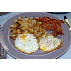 Breakfast plate of fried foods - bacon, eggs, and hashbrowns.(Credit: American Heart Association)