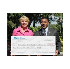 WellCare’s chief pharmacy officer, Laura Hungiville, presents Dr. Kevin Sneed, dean of the college of pharmacy, University of South Florida, with $4,400 to fund the college’s White Coat Ceremony.