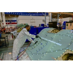 An F-35 technician performs a skin assembly process with work instructions projected on the structure as one of the innovative solutions for high rate military aircraft production.