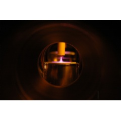 Helium plasma is generated between a point anode and planar dielectric cathode in a lab at Sandia National Laboratories, which is setting up a collaborative facility to study low-temperature plasmas. (Photo by Ed Barnat)