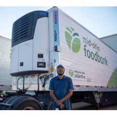 Through its program to help food banks in the Feeding America network, Carrier Transicold provided the Mid-Ohio Food Bank with this X4 Series trailer refrigeration unit, shown with Malik Perkins, public relations manager for the food bank.