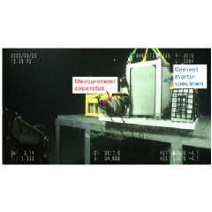 Measurement apparatus next to cement mortar specimen at a water depth of approximately 3,500 meters (Copyrighted image courtesy of JAMSTEC)
