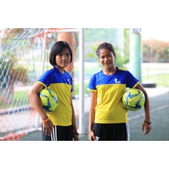 Nichada Hanchengchai, left, and Jennapa Maksawat, both sixth-grade students at Wat Yaichomprasat School, are pictured during a football clinic organized by Thai Union and Samut Sakhon Football Club.