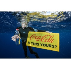A Greenpeace diver holds a banner reading Coca-Cola is this yours? and a Coke bottle found adrift in the Great Pacific Garbage Patch. Even hundreds of kilometres from any inhabited land, plastic can be found polluting our environment.
