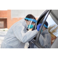 Kelly Brothers, RN, a nurse at UCSF wears an N95 mask and face shield while testing a person for COVID-19. Photo by Susan Merrell
