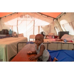 UNICEF/UN0503621/Rouzier
Karl, 15 months, sits in a UNICEF-supplied tent in the temporary shelters at Phillipe Guerrier High School in Les Cayes, Haiti.