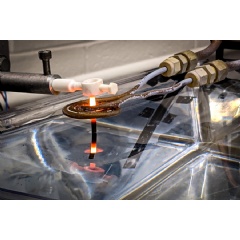 A thin rod of 3D-printed superalloy is drawn out of a water bath, and through an induction coil, where it is heated to temperatures that transform its microstructure,(see complete caption below)
