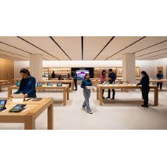 Customers enter Apple Saket though a uniquely designed curved storefront with white oak tables displaying Apple’s products and accessories.