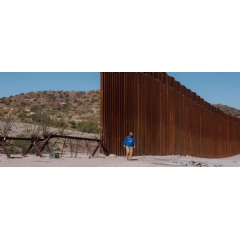 A volunteer with Humane Borders inspects an area east of Sasabe, Arizona, where the border wall ends and smaller barriers are set up to prevent people from crossing into the US. | United States 2023 © Christopher Lee