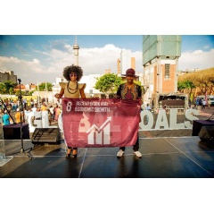 Singing duo Mafikizolo raised a flag to represent Goal 8, Decent Work and Economic Growth, at Constitution Hill in Johannesburg, South Africa, to support the UN Global Goals for Sustainable Development. Credit: Nicki Priem