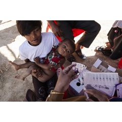  UNICEF/Brown - 
A young woman and a baby waiting to be immunized watch as a health worker fills a syringe with vaccine, in the Unchiprang makeshift Rohingya refugee camp in Coxs Bazar