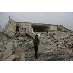 © UNICEF/UN018873/Alshawi
A child stands in front of his ground-flattened school after an bombardment in Ainjara village in rural Aleppo on 11 January 2016. More than 20 children died or were injured as a result of an attack in the area.