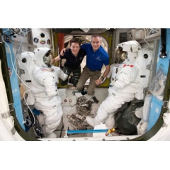 Astronauts (from left) Anne McClain and David Saint-Jacques are pictured in between a pair of spacesuits that are stowed and serviced inside the Quest airlock where U.S. spacewalks are staged.
Credits: NASA