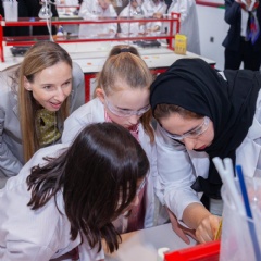 Dr. Simone Bagel-Trah, Chairwoman of the Supervisory Board and the Shareholders Committee of Henkel, watching kids while conducting experiments