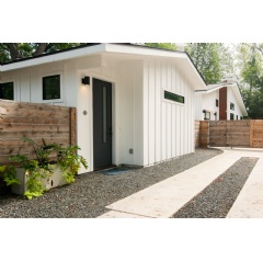 Exterior of a white studio stay with a black door and parking spot adjacent to it.
Modern, Serene Studio in Hip East Austin